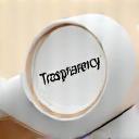 A clear magnifying glass revealing 'Transparency' on paper, with a subtle golden glow.